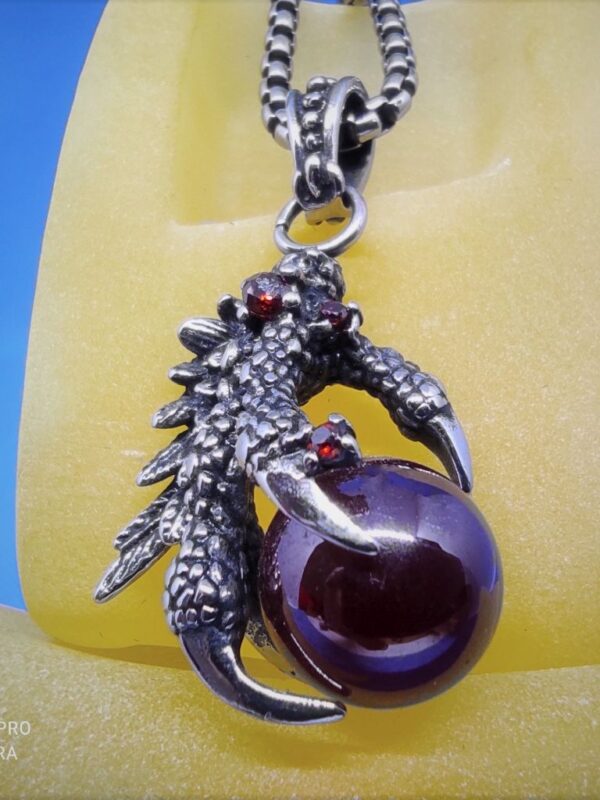 Pendentif gothique acier motif griffe de dragon tenant une boule rouge en pierre, style gothique rock biker